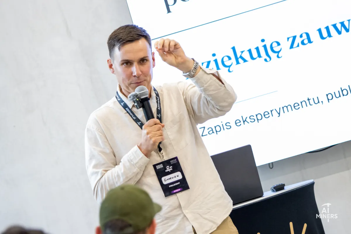 Grzegorz Brzezinka speaking with a microphone in front of a slide, at the AI Miners meetup in Katowice